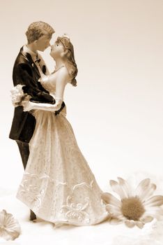 A wedding cake topper in a sepia toned image.