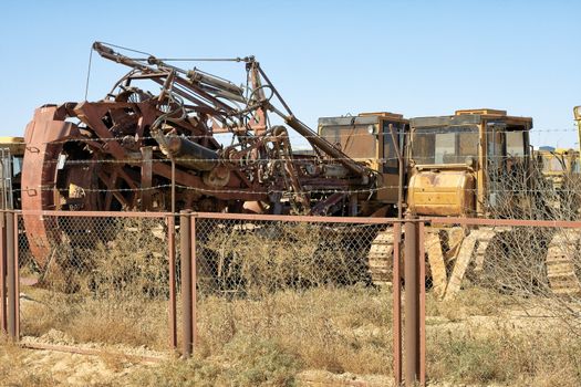 Old broken and abandoned tractor standing near the fence.