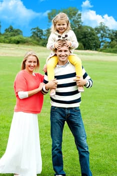 Cheerful family posing against nature background. Full length portrait