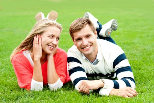 Romantic young couple outdoors in the park. Lying and relaxing