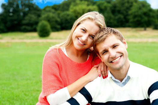 Lovely young couple striking a smiling pose, outdoors