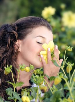 Close up of a girl holding and smelling a beautiful flower