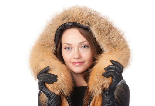 Beautiful smiling woman in fur trimmed jacket with hood keeping warm against the winter cold isolated on white