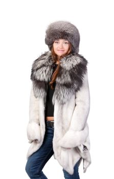 Sexy woman wearing a stylish winter fur coat and hat for protection against the bitter cold on a white background