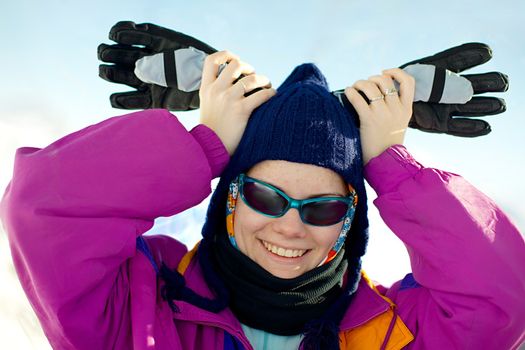 Skier woman being playful with gloves