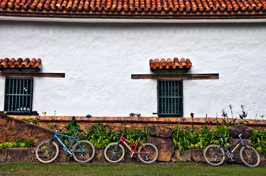 Three bicycles resting against the wall of an old Spanish Monastery.