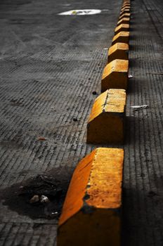 Yellow concrete blocks marking off parking places.