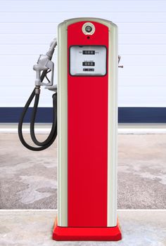 Ancient gas pump painted in bright dark blue and orange in the setting of an old gas station