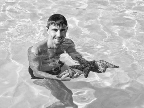 Man with 3 Starfishes in the Caribbean Sea