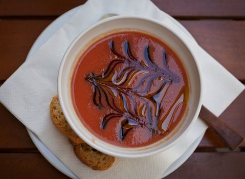 A bowl of delicious cold gazpacho soup served in a Spanish summer garden.