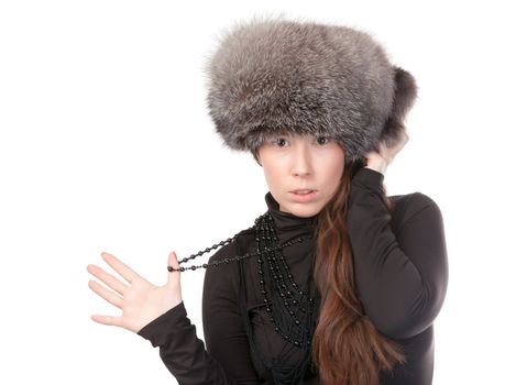 Vivacious woman in a winter outfit with a fur hat on white background