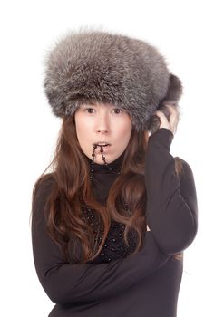 Vivacious woman in a winter outfit with a fur hat on white background