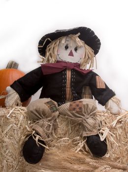 Scarecrows on haystack with pumpkin