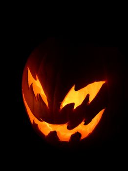 A spooky pumpkin face glowing on Halloween night.
