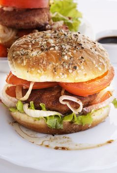 Burger with meat and baked vegetables on a white background