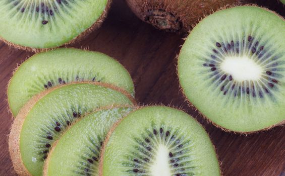 Background of Perfect Raw Kiwi Fruits on Wooden plate closeup