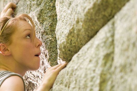 Female rock climber climbing a stone structure