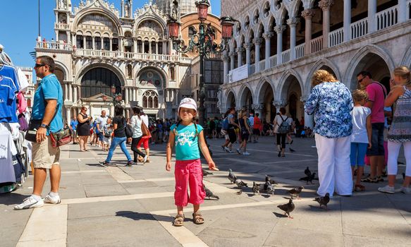 16. Jul 2012 - Small girl with pigeons in St Marco Square, in front of Doge's Palace in Venice, Italy