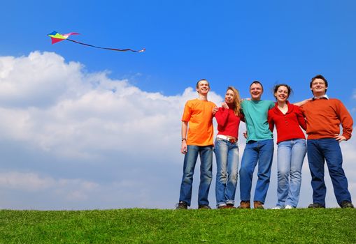 Group of people smiling against blue sky                                    