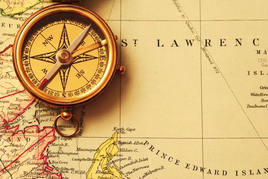 Antique brass compass over old Canadian map background