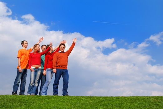 Group of people pointing to sky with clouds                
