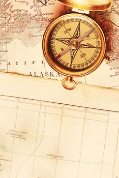 Antique brass compass over old Alaska map                                    