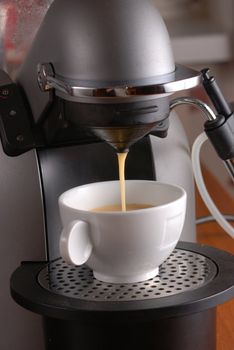 Coffee machine pouring espresso in cup