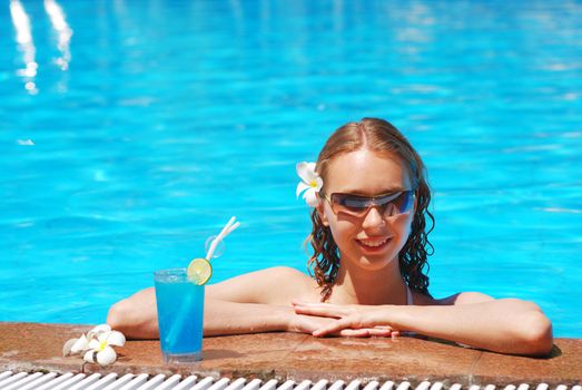 Girl in tropical pool with cocktail