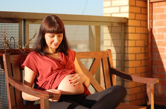 Pregnant woman waiting for a first child. Sunlight.