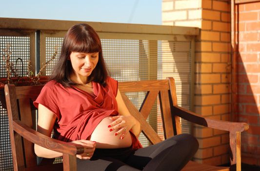Pregnant woman waiting for a first child. Sunlight.