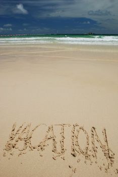 "Vacation" word written on a tropical beach