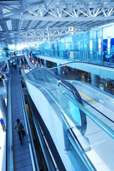 Travelator with people in airport. No recognizable faces or brandnames. Toned Cold.