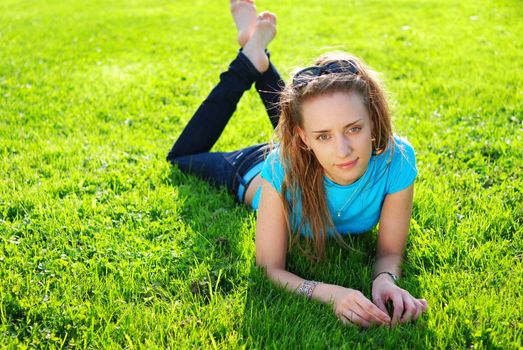 Girl laying on fresh green grass