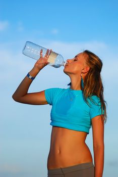 Woman drinking water after jogging