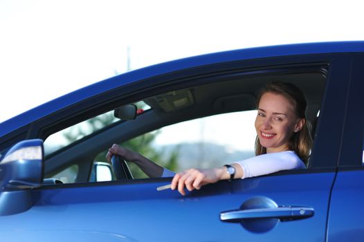 Happy woman in new blue car