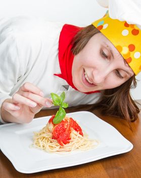  smiling chef garnish an Italian pasta dish 