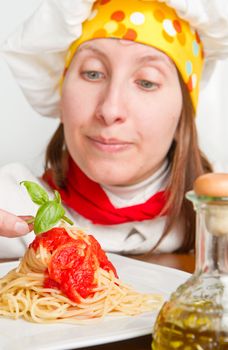  smiling chef garnish an Italian pasta dish 