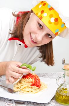  smiling chef garnish an Italian pasta dish 