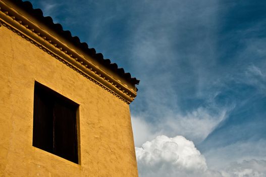 A yellow colonial building set against a blue sky in Santa Fe de Antioquia, Colombia.