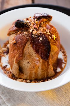 baked apple with a coat of cinnamon dough and an orange Grand Marnier sauce on wooden table as background