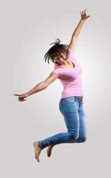 pretty modern slim hip-hop style woman jumping dancing on a grey background