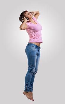 pretty modern slim hip-hop style woman jumping dancing on a grey background