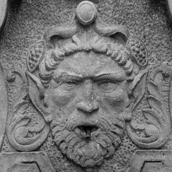 Dolceacqua town, Italy. Medieval fountain with elf head, 13th century