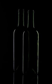 Two wine bottles on a black background