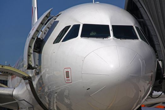 Front detail with cockpit windows of passenger wide-body jet airplane