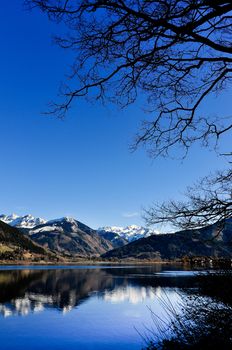 Mountain lake landscape view with tree and mountains reflection, Zell am See, Austria