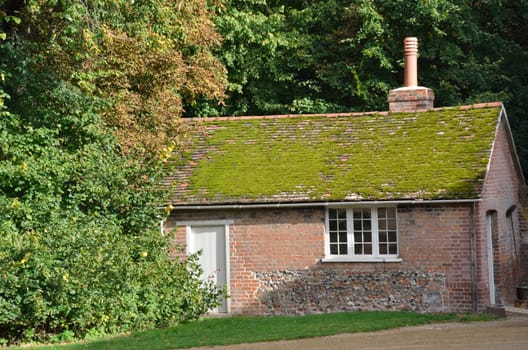 Moss Roofed red brick cottage