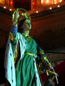 A papier mache statue of Saint Catherine being part of various street decorations for the feast of Saint Catherine in Zejtun, Malta.