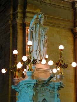 A stone sculpture of Saint Catherine in the church square of Zejtun, Malta.