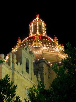The dome of a church in Zejtun in Malta brightly lit for the feast of Saint Catherine.